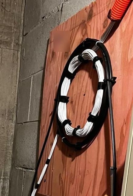 White and black fiber cables neatly bundled into a loop on a backboard